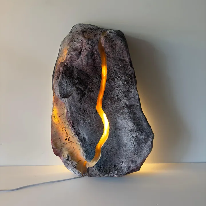 Stone-form sculpture lamp split by a glowing fissure of light
