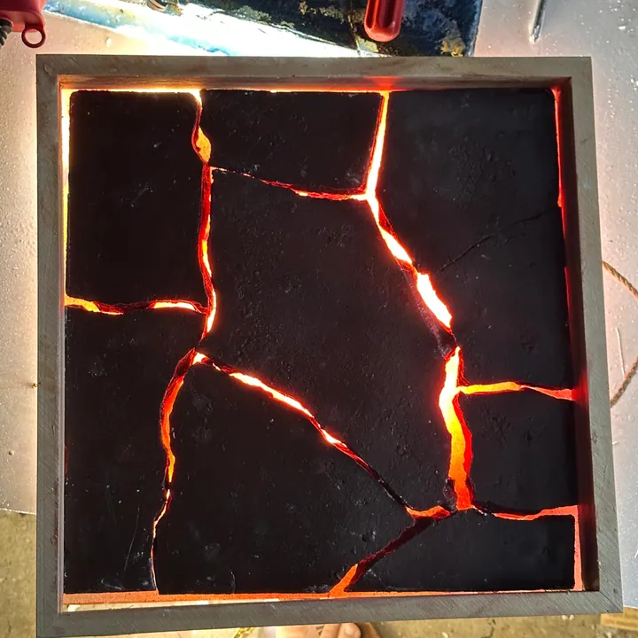 Black textured wall panel with glowing lava-like cracks