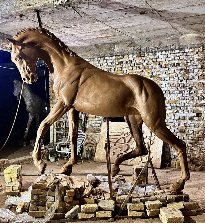 Life-size horse sculpture in clay over armature inside the workshop